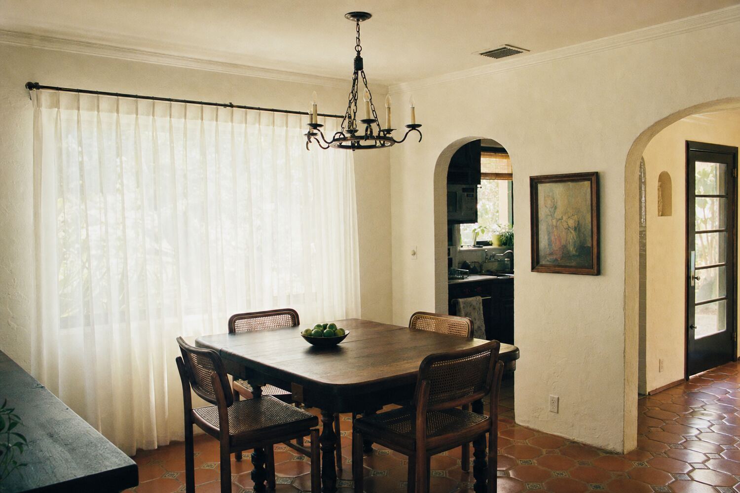 Full-length drapery panels framing a window in a paneled room