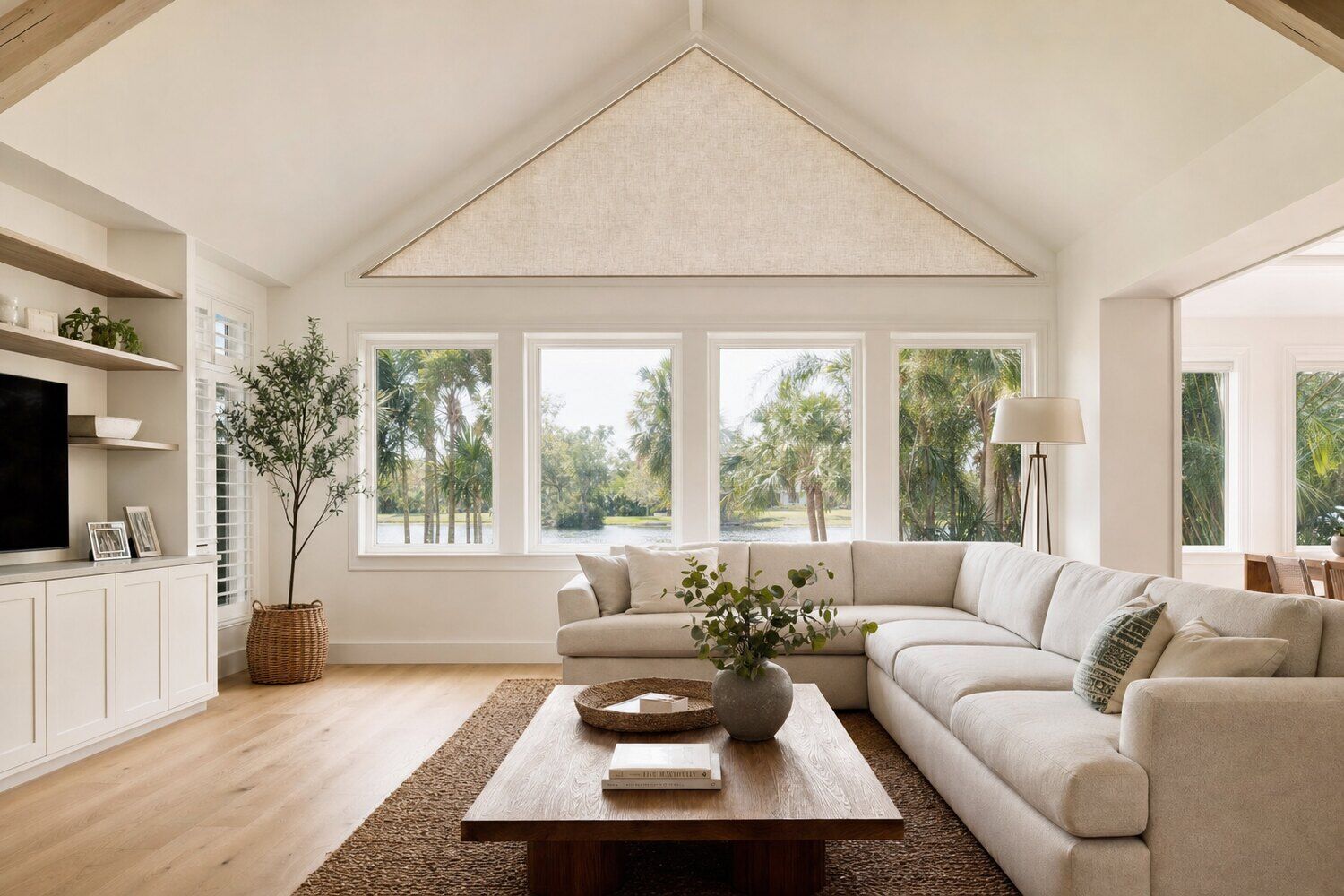 An unusually shaped window treated to follow its outline in a double-height room